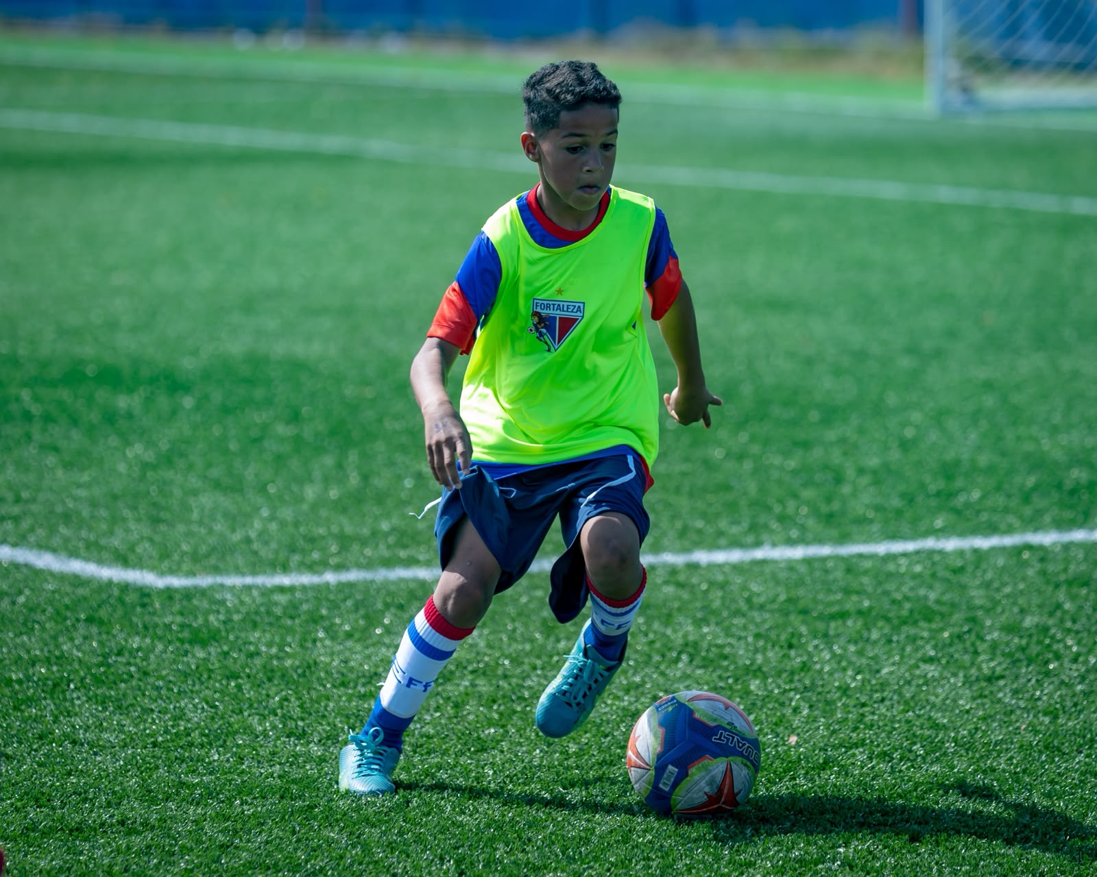 Aluno da Escola de Futebol Fortaleza conduzindo a bola